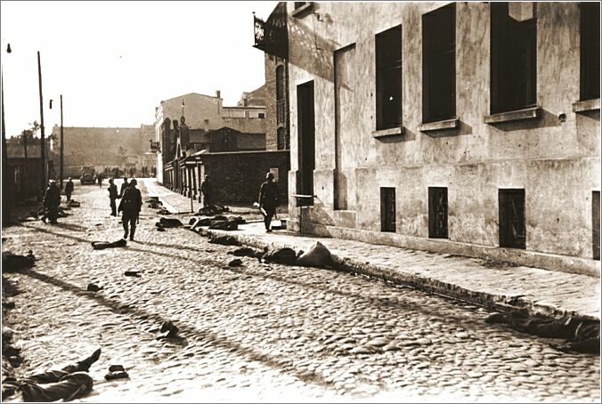 German soldiers patrol a street in Czestochowa, where dead bodies lie strewn along the pavement